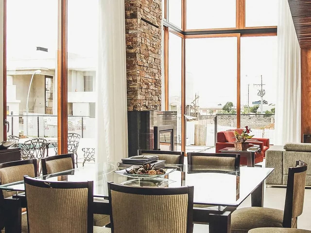 Dining room with tall timber windows and a fireplace