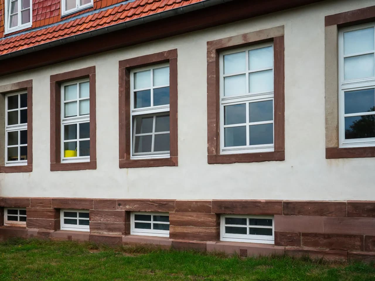 Historic building with white-painted timber windows in red surrounds