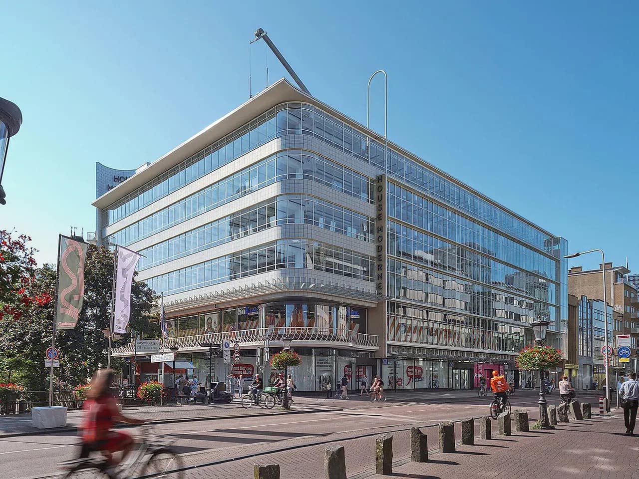 Volledig beglaasd winkel- en kantoorgebouw aan een stadsplein