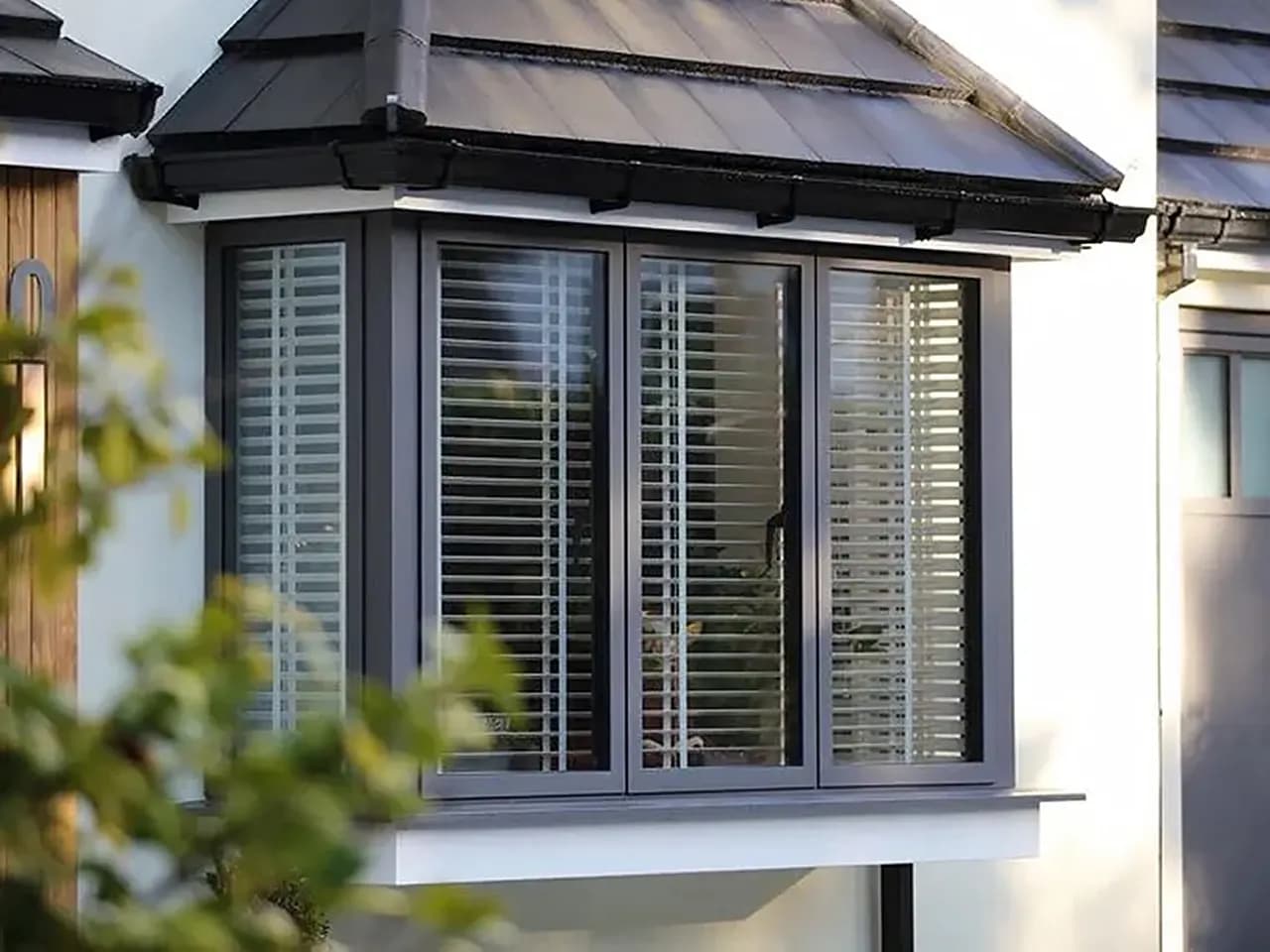 Bay window with anthracite aluminium windows and shutters