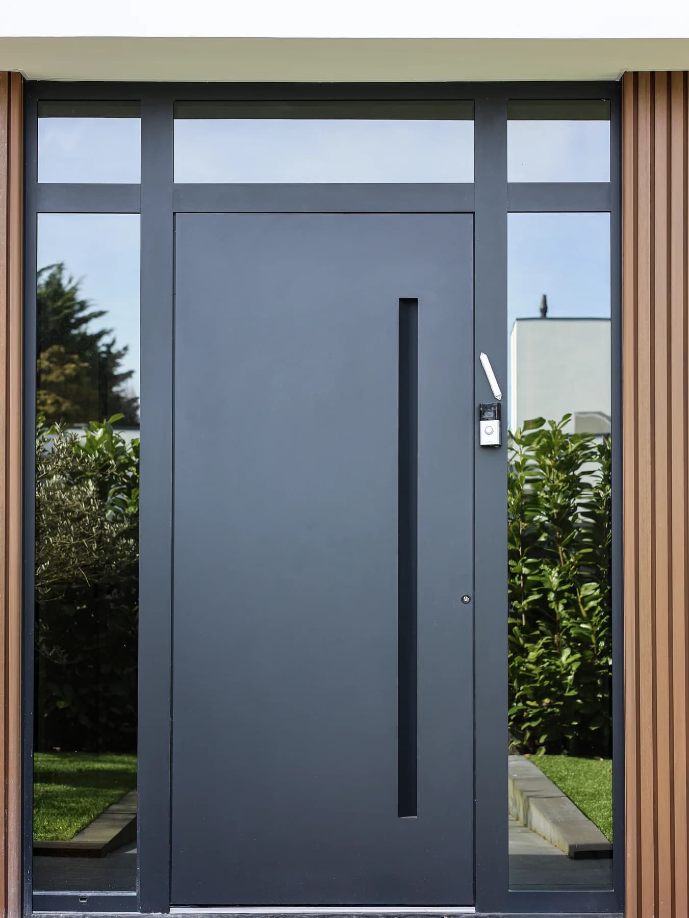 Dark front door with tall glazing and a side light
