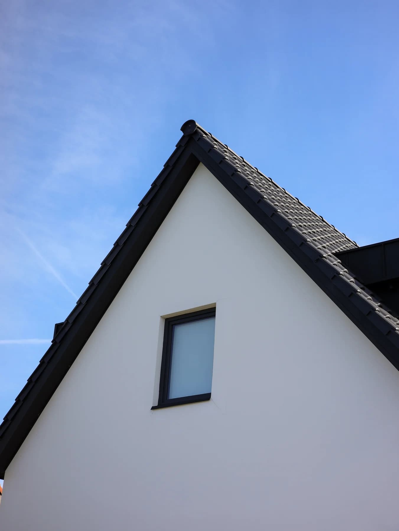 Raam in de puntgevel onder een donker pannendak