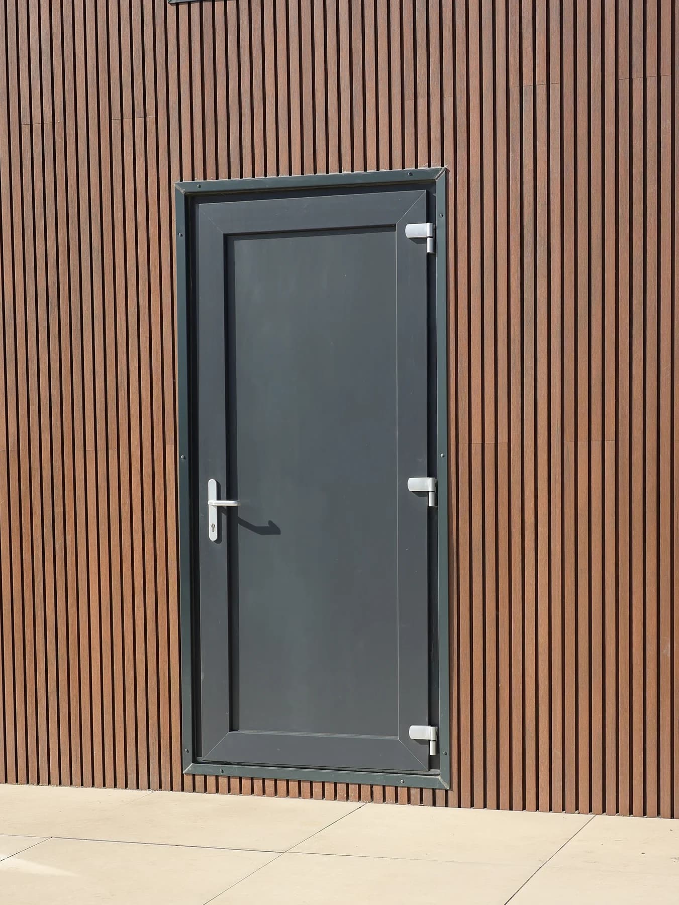 Dark external door in a vertically clad timber facade