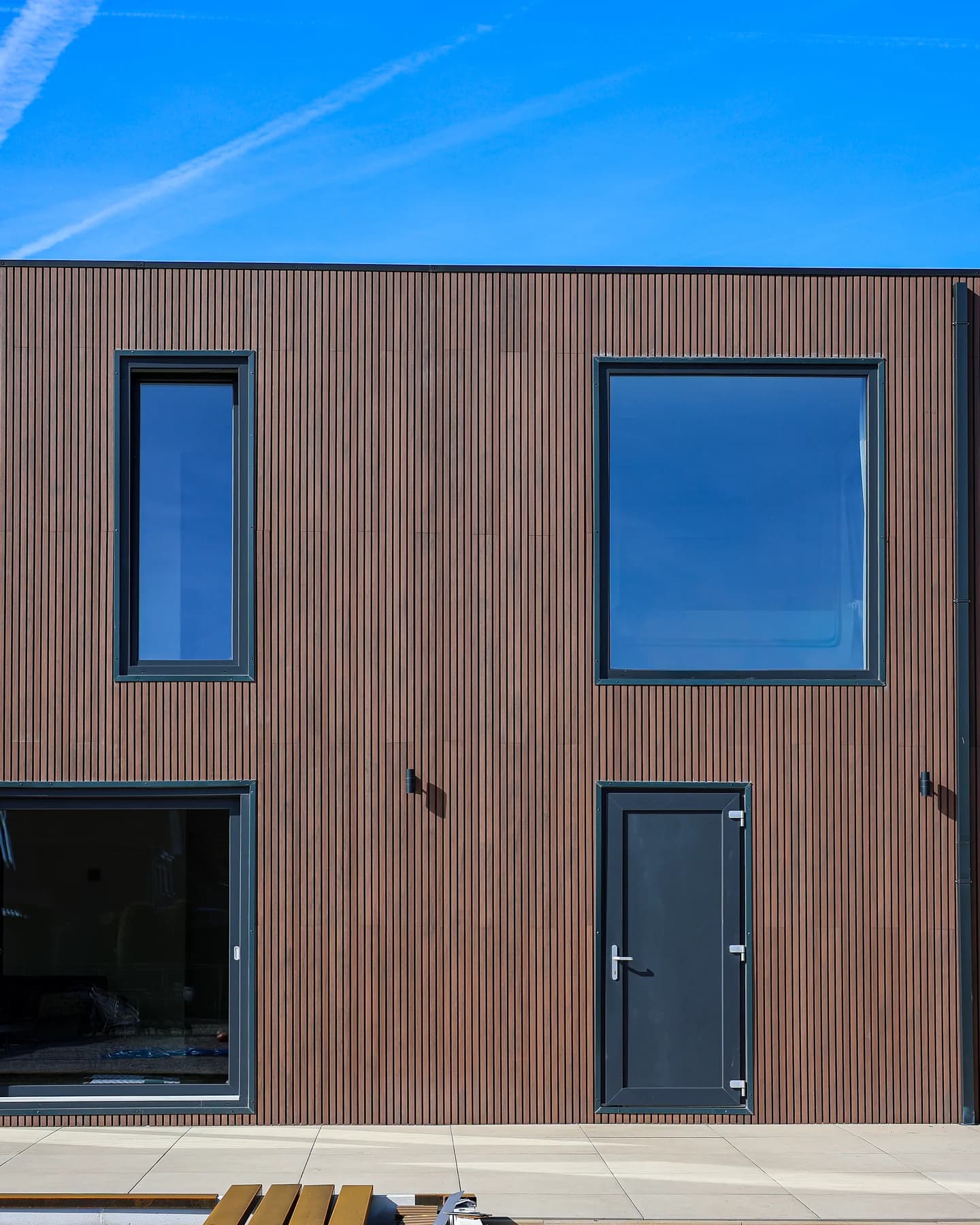 Window and entrance door integrated into timber cladding