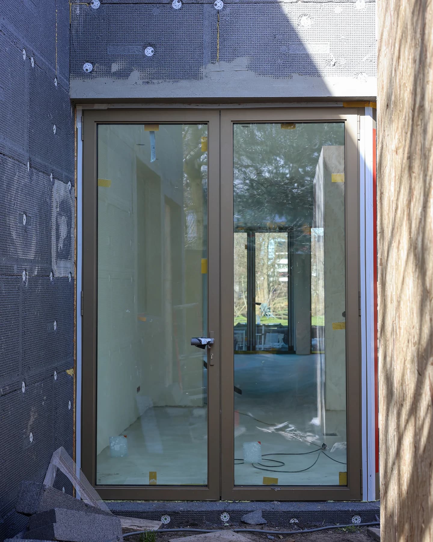 Nieuwe glazen buitendeur tijdens de gevelrenovatie